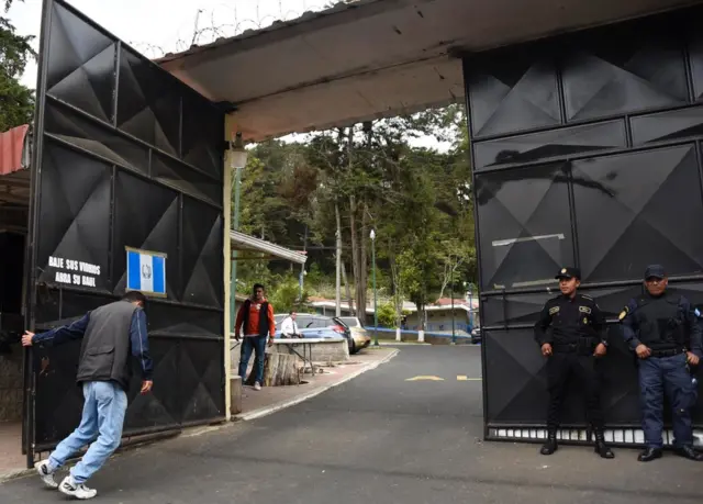 Un hombre cierra el portón del Hogar Seguro Virgen de la Asunción de Guatemala.