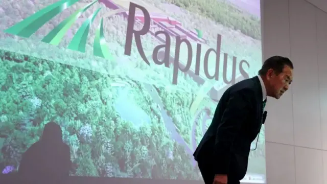 一名男子在螢幕前鞠躬