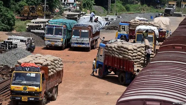An Indian labourer loads grain sakcs on to a truck at a railway goods yard in Chennai on August 3, 2016.