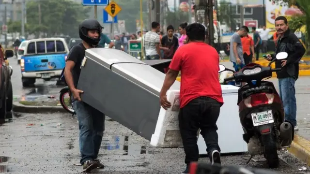 Dos hombres se llevan un refrigerador