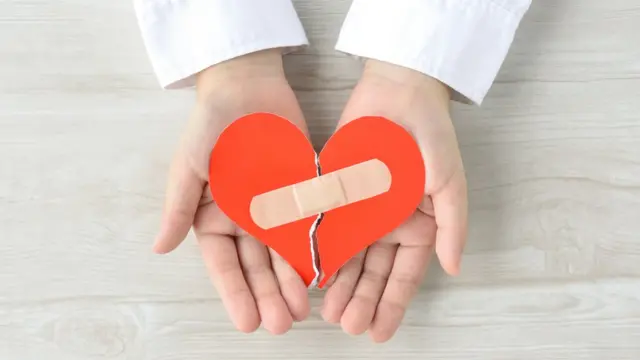 Unas manos con un corazón y una curita