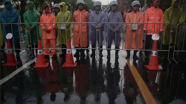 เจ้าหน้าที่ตำรวจยืนตรึงกำลังท่ามกลางสายฝน