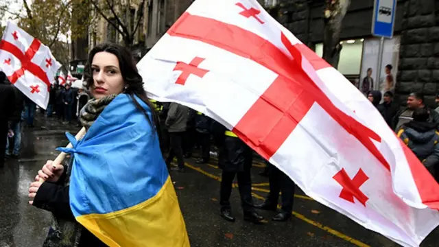 Дівчина з прапорами України та Грузії