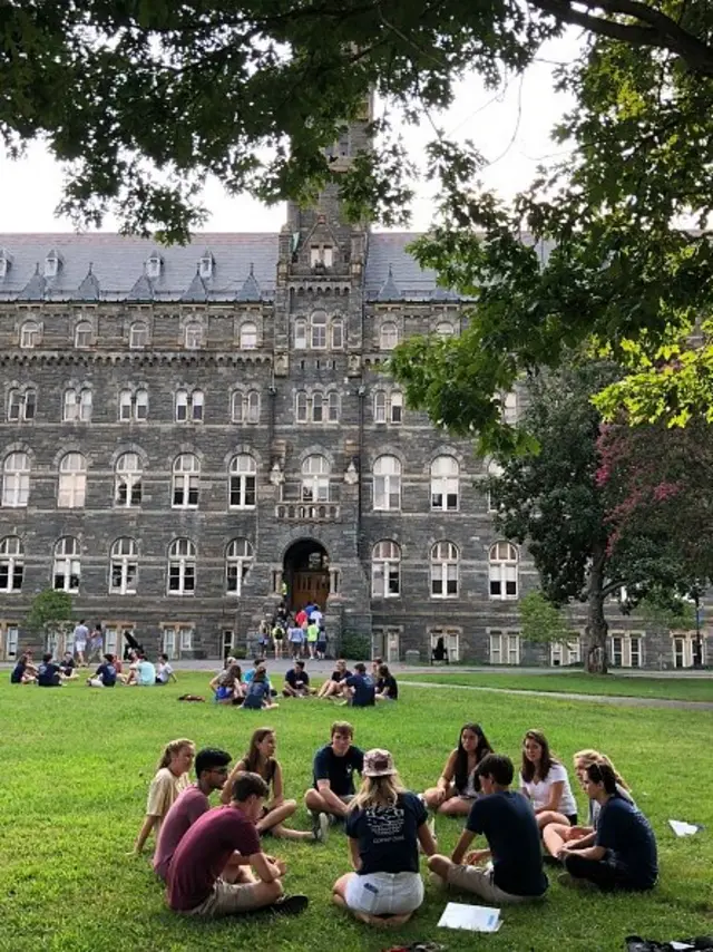 คนนั่งล้อมวงในสนามหญ้า