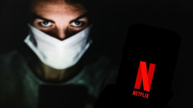 Chico con mascarilla mostrando celular con logo de Netflix