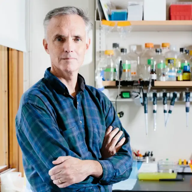 Чоловік у синій картатій сорочці в лабораторії