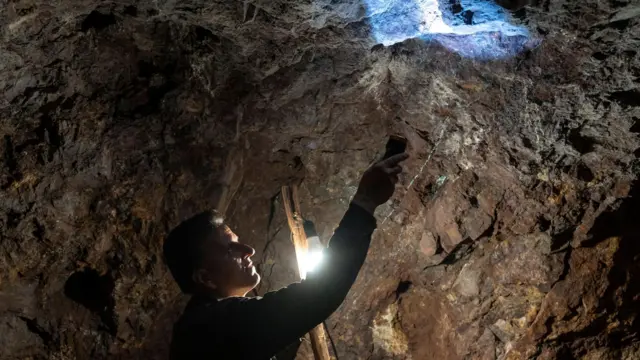 عامل منجم يُسلط الضوء على جدار داخل منجم الفيروز في نيسابور، إيران، في 6 أكتوبر/تشرين الأول 2024.