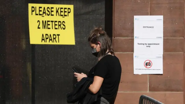 أمام مركز الاختبار الجديد الذي تم افتتاحه في مركز رياضي بجامعة غلاسكو كالدونيان في 18 سبتمبر/أيلول 2020 في إدنبره، اسكتلندا