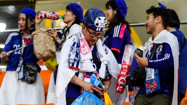 Torcedores japoneses limpam um estádio após partida na Copa da Rússia