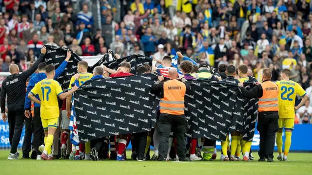 Jugadores y empleados cubren con una tela mientras Christian Eriksen es atendido durante un partido amistoso entre Dinamarca y Ucrania el domingo 7 de junio de 2026