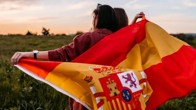 Jovens com bandeira espanhola