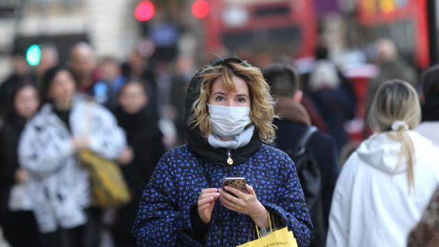 Una mujer usando una mascarilla en la calle en Londres.