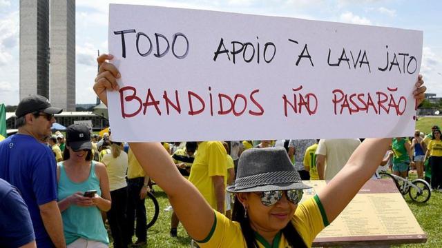 Manifestante segura cartaz escrito "Todo apoio à Lava Jato, Bandidos não passarão"