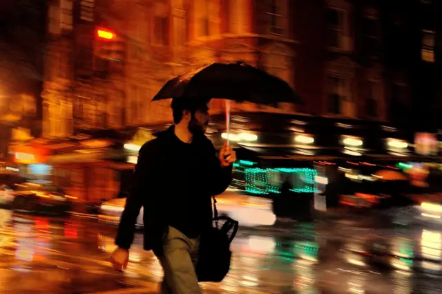 شخص يمسك بمظلته تحت المطر