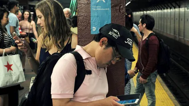 People looking at phones on the New York subway