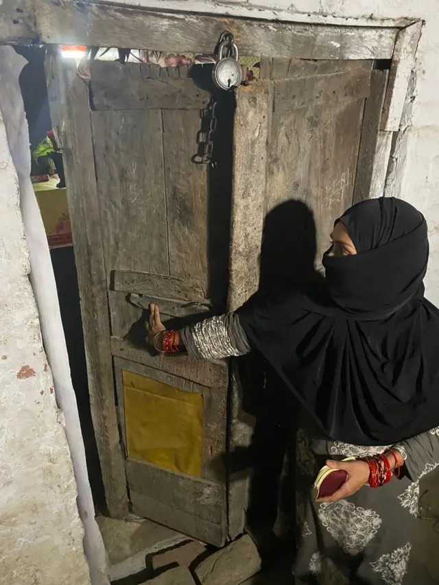 आसिफ़ अली की पत्नी चाँद बी अपने घर का टूटा दरवाज़ा दिखाते हुए