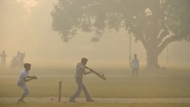 দিল্লির একটি পার্কে ছেলেরা ক্রিকেট খেলছে: বায়ুদূষণের মাত্রা ছবি থেকেই স্পষ্ট