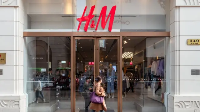 Woman walks by H&M store in Shanghai