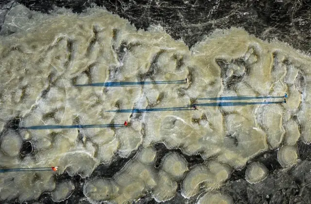 An image taken with a drone shows people skating on natural ice in Zuiderwoude, The Netherlands, 11 February 2021