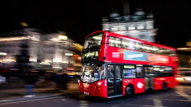 A bus travels through central London at night