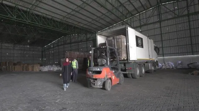 Workers load food supplies on to a lorry at a World Food Programme warehouse in Gaza