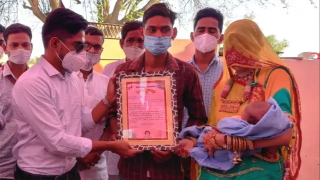 हनुमान प्रजापत और चुकी देवी को सम्मानित करते अधिकारी