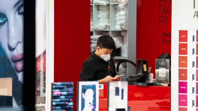 Человек в маске в магазине косметики