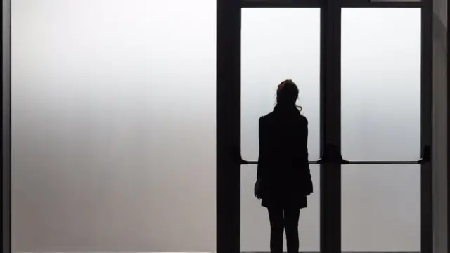 Mujer rmirando por ventana