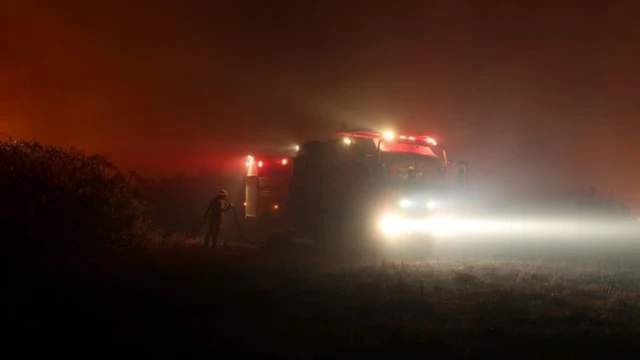 Caminhão e bombeiro no meio da estrada à noite