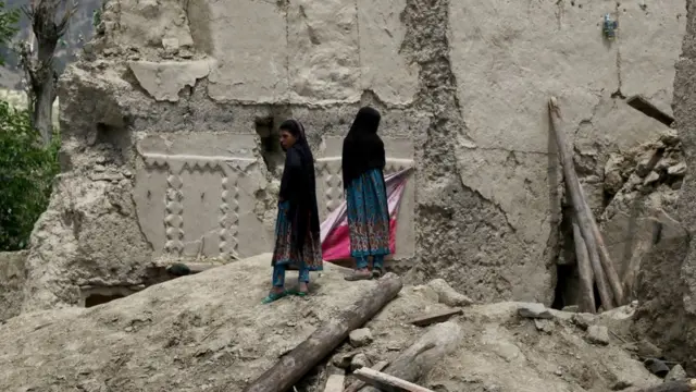 فتاتان خارج أحد المنازل المدمرة