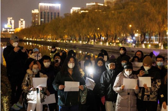 11月27日，在悼念烏魯木齊火災遇難者活動期間，北京市民聚集在一起守夜並舉著白紙抗議當局的新冠封控措施。