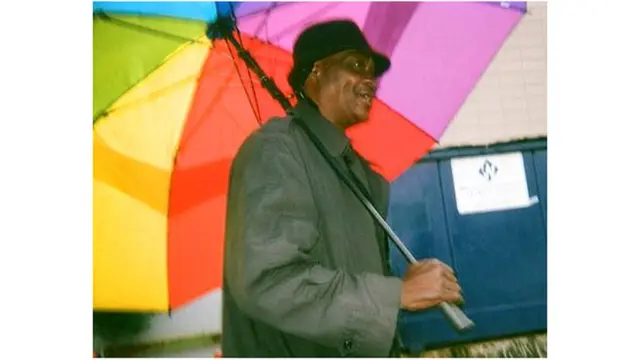 Hombre con una sombrilla de colores.