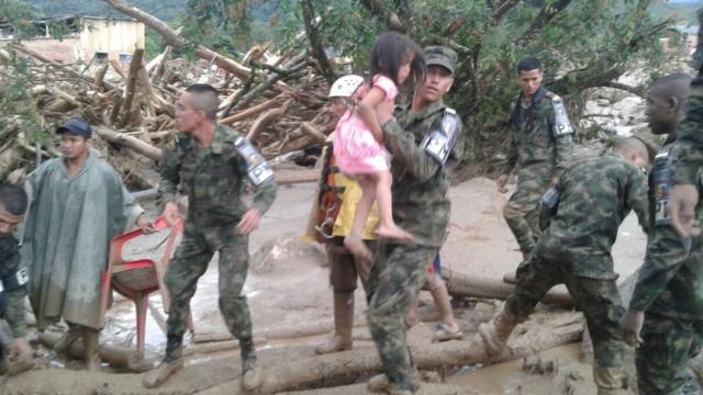 Soldado rescata a una niña de los escombros.