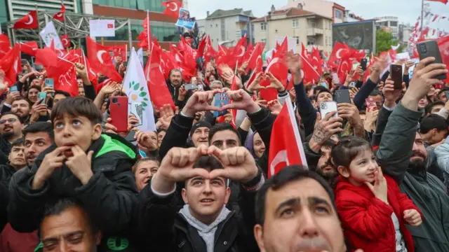 مؤيدون يرسمون بأصابعهم رمزًا للقلب أثناء مسيرة للحملة الانتخابية الرئاسية