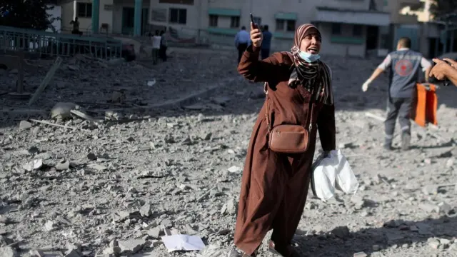 فلسطينية تفر عقب غارة إسرائيلية.