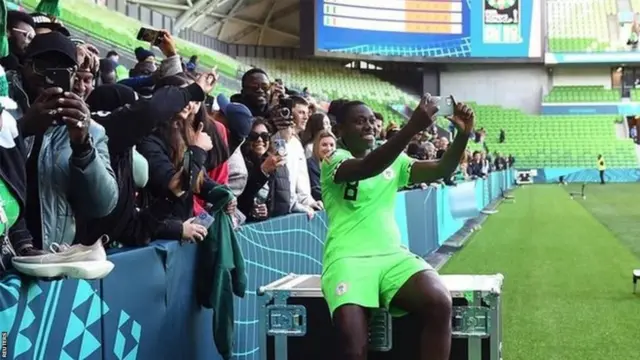 Asisat Oshoala prend un selfie avec des fans.