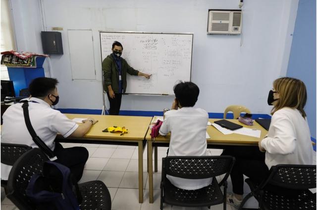 2020年1月29日，菲律宾马尼拉以东奎松市的一所华裔菲律宾学校，十二年级的老师和他的学生在上课时戴上防护口罩。