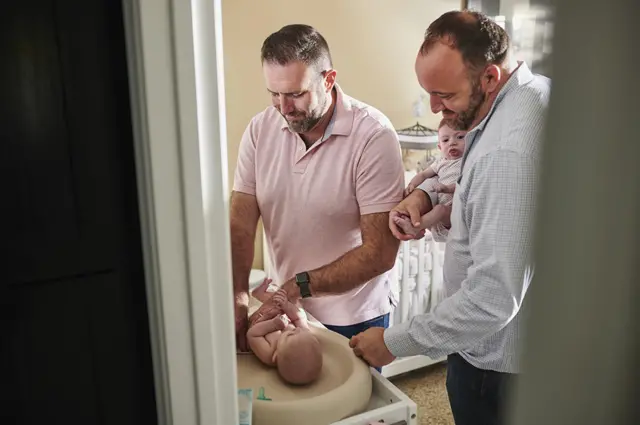 Dos hombres cambian a sus bebés