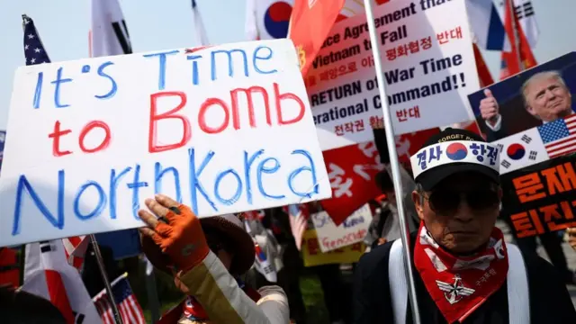 Не все довольны визитом Ким Чен Ына. На демонстрации протеста были видны плакаты с надписью "Пора бомбить Северную Корею"