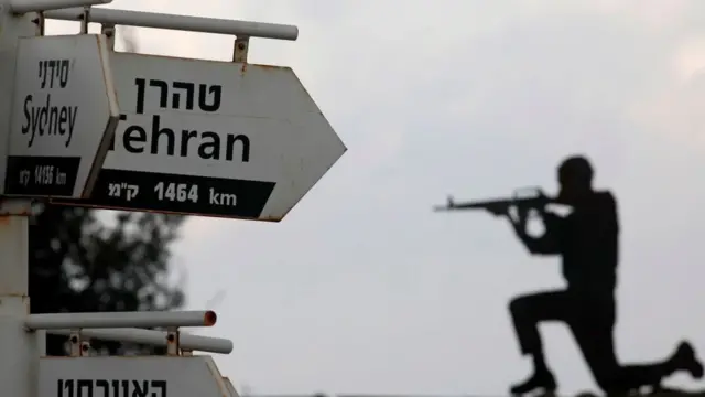 اس فائل فوٹو میں ایک اسرائیلی فوجی گولان کی پہاڑیوں میں اسرائیلی قبضے والے ماؤنٹ بینٹل کی فوجی چوکی پر بیٹھا ہے۔ اس کے ساتھ ہی وہ بورڈ نظر آ رہا ہے جہاں مختلف ممالک کے یہاں سے فاصلے کی نشاندہی کی گئی ہے