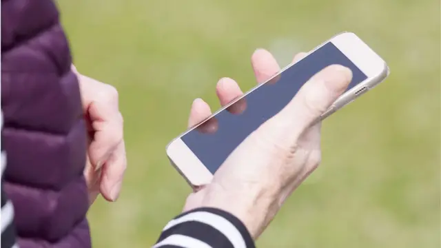 شخص يحمل هاتفا ذكيا