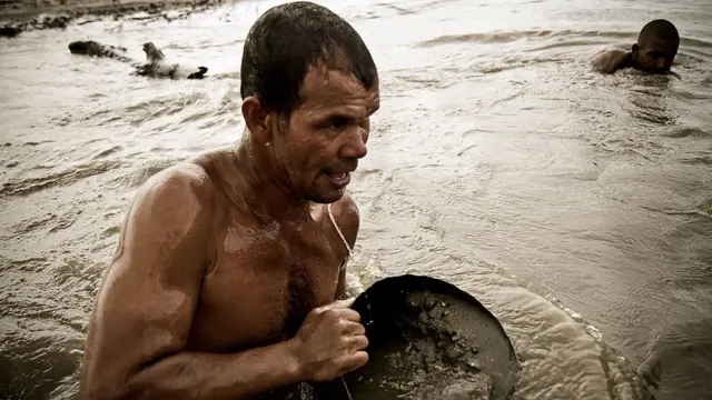 Arenero sacando arena del río.