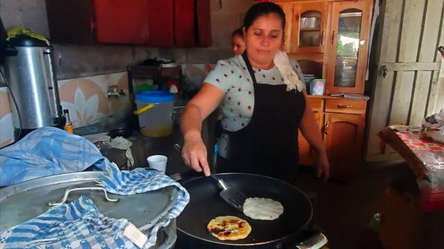 Mujer cocinando pupusas