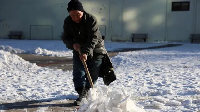 雪かきをする北京の男性（22日）