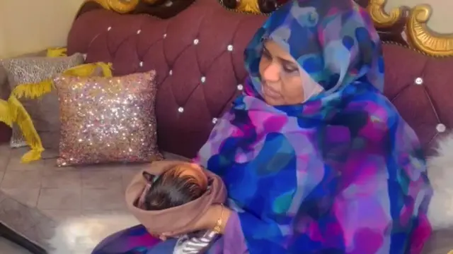 Bashayer holding her baby daughter on her knew