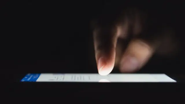 Telefon ekranı üzerinde görülen bir parmak