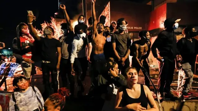 محتجون يتظاهرون بالقرب من قسم الشرطة في مدينة مينيابوليس بولاية مينيسوتا في مايو/أيار 2020 بعد مقتل جورج فلويد أثناء اعتقاله