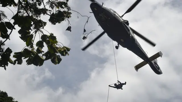 เจ้าหน้าที่โรยตัวลงมาจากเฮลิคอปเตอร์ลงบนพื้นที่ ซึ่งทีมนักสำรวจโพรงปักหลักอยู่