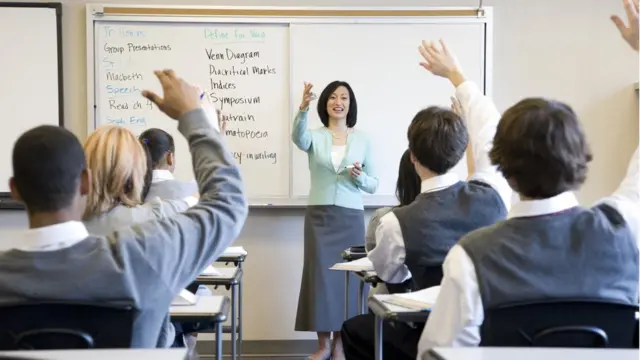 School children (14-18) raising hands in class at Interlake High School, USA, Washington State, Bellevue.