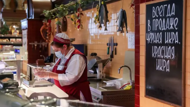 Mulher trabalha na mercearia Yeliseyevsky na Rua Tverskaya,